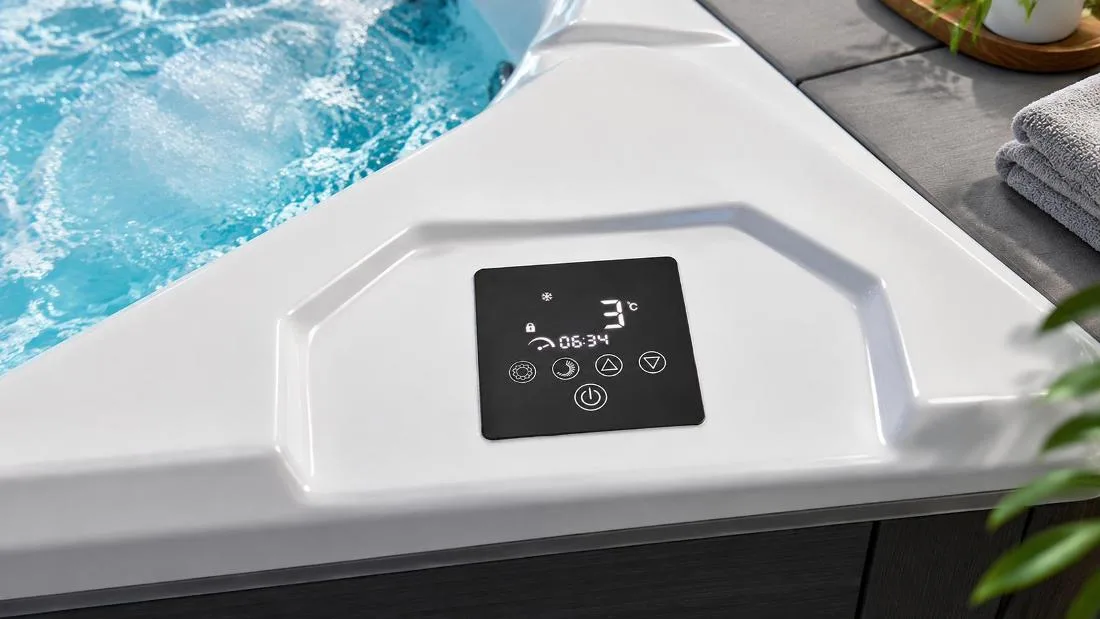 Digital touchscreen control panel on acrylic ledge Close-up top-down view of the built-in digital touch control panel on the white acrylic tub ledge displaying a 3°C temperature readout