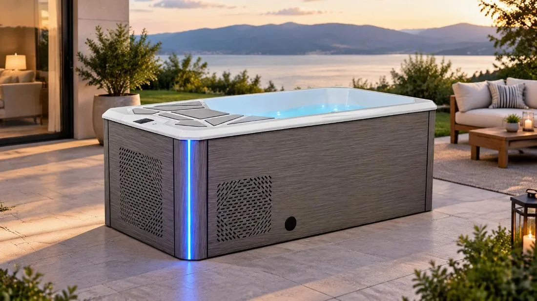 Freestanding cold plunge tub with composite wood cabinet Three-quarter perspective studio shot of the OF-CP02 cold plunge tub showing horizontal grey wood-grain exterior cabinetry and illuminated blue water